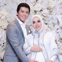 Penampilannya serasi dengan sang suami, Reino Barack, yang memakai setelan jas abu-abu serta kemeja putih. Foto: instagram Syahrini