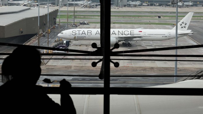 A woman eats as the Singapore Airlines aircraft for flight SQ321 is parked on the tarmac after an emergency landing at Suvarnabhumi International Airport, in Bangkok, Thailand, May 22, 2024. REUTERS/Athit Perawongmetha