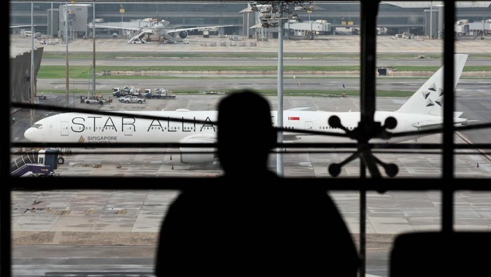 Usai Turbulensi, Pesawat Singapore Airlines Terparkir di Bandara Suvarnabhumi A woman eats as the Singapore Airlines aircraft for flight SQ321 is parked on the tarmac after an emergency landing at Suvarnabhumi International Airport, in Bangkok, Thailand, May 22, 2024. REUTERS/Athit Perawongmetha