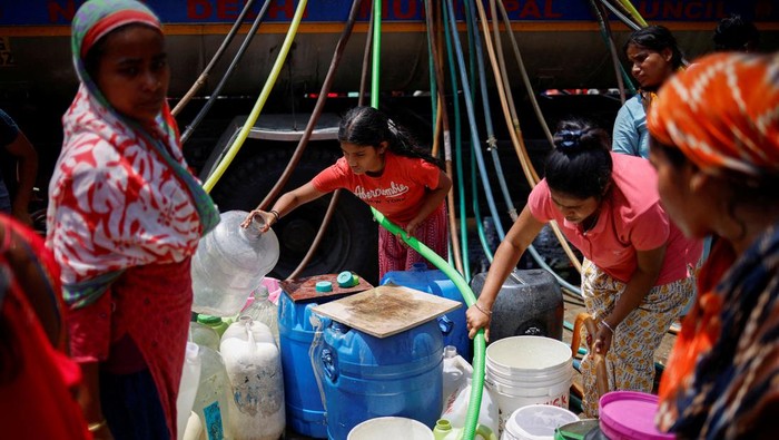 Residents fill their containers with drinking water from a municipal tanker on a hot summer day in New Delhi, India, May 21, 2024. REUTERS/Adnan Abidi