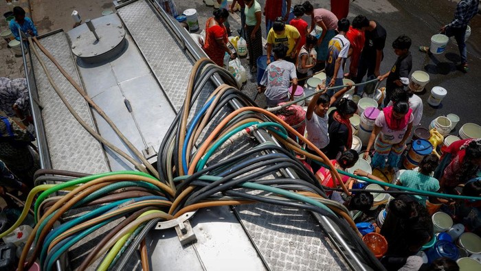Residents fill their containers with drinking water from a municipal tanker on a hot summer day in New Delhi, India, May 21, 2024. REUTERS/Adnan Abidi