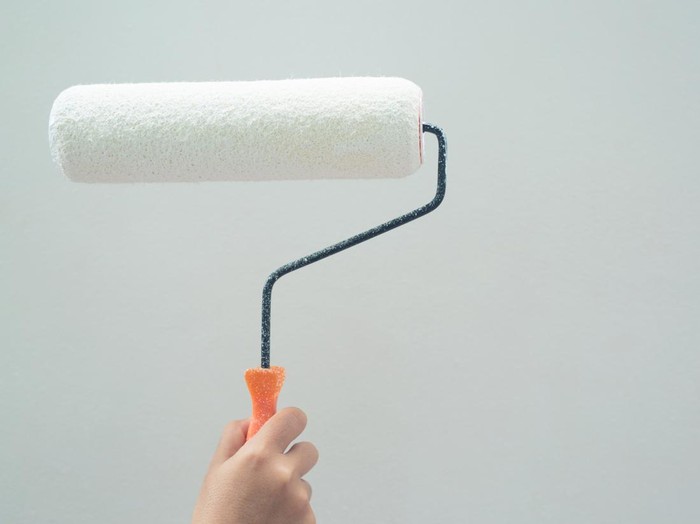 Roller Brush Painting, Worker painting on surface wall  Painting apartment, renovating with white color  paint. Leave empty copy space white to write descriptive text beside.