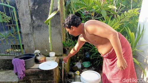 Warga di Desa Pecatu, Kecamatan Kuta Selatan, Badung, melihatkan debit air keran PDAM miliknya di rumah yang kecrat-kecrit, Kamis (23/5/2024).