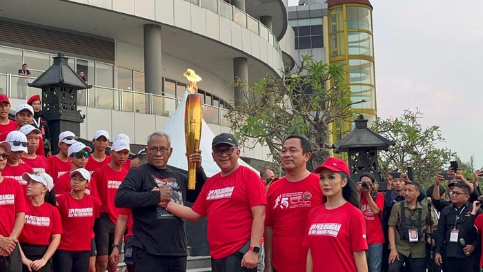 Ketua DPP PDIP Komarudin Watubun menerima api obor dari Mrapen, Jawa Tengah dari Sekjen PDIP Hasto Kristiyanto.