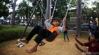Seorang anak asyik bermain ayunan di Tebet Eco Park.  