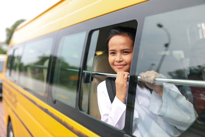 Elementary student riding bus to school