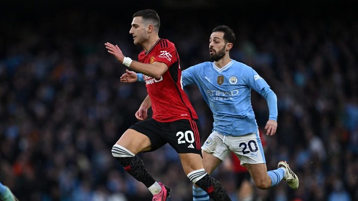 Manchester Uniteds Portuguese defender #20 Diogo Dalot (L) runs away from Manchester Citys Portuguese midfielder #20 Bernardo Silva (R) during the English Premier League football match between Manchester City and Manchester United at the Etihad Stadium in Manchester, north west England, on March 3, 2024. (Photo by Paul ELLIS / AFP) / RESTRICTED TO EDITORIAL USE. No use with unauthorized audio, video, data, fixture lists, club/league logos or live services. Online in-match use limited to 120 images. An additional 40 images may be used in extra time. No video emulation. Social media in-match use limited to 120 images. An additional 40 images may be used in extra time. No use in betting publications, games or single club/league/player publications. /