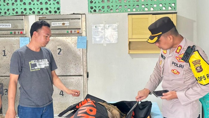 Polisi saat mengevakuasi korban travel terseret banjir di OKU ke rumah sakit.