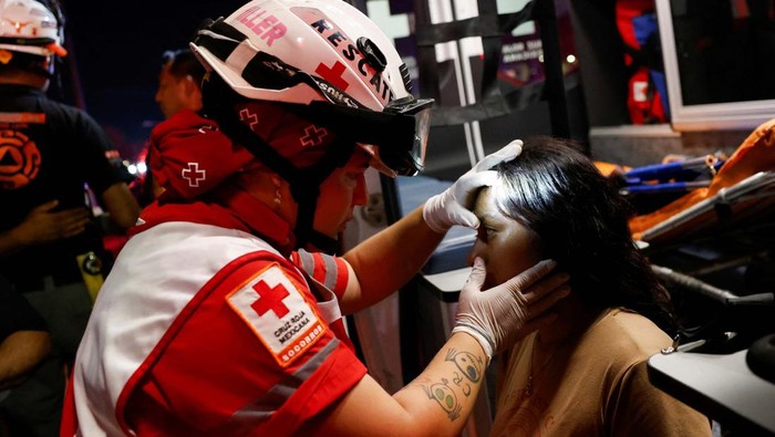 A Mexican Red Cross rescuer checks a girl at the site after a gust of wind caused a structure to collapse, resulting in multiple fatalities and injuries, at a campaign event for the Citizens' Movement party, in San Pedro Garza Garcia, Nuevo Leon, Mexico May 22, 2024. REUTERS/Daniel Becerril