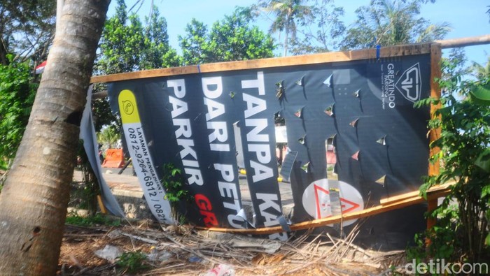 Spanduk imbauan bayar parkir hanya sekali di Pantai Pangandaran.