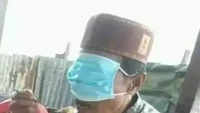 Seorang pria yang sedang datang ke sebuah acara ini kebingungan meletakkan masker saat makan. Alhasil, ia memilih menutup matanya agar bisa makan dengan lahap. Foto: 1cak.com