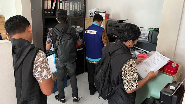 Penyidik Satreskrim Polres Malang saat melakukan penggeledahan di Kantor Dispendukcapil.