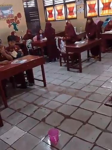 Siswa SDN 1 Jatibaru belajar di dalam kelas yang atapnya bocor.