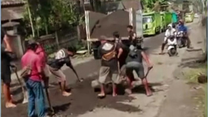 Viral sejumlah sopir truk menambal jalan berlubang pakai pasir di Kecamatan Selat, Karangasem.