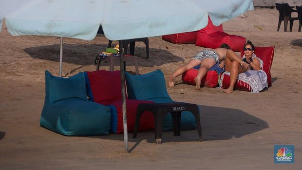 Wisatawan mancanegara beraktivitas di Pantai Kuta, Denpasar, Bali, Sabtu (25/5/2024). Pantai Kuta masih menjadi primadona wisatawan mancanegara yang berkunjung ke Bali. (CNBC Indonesia/Faisal Rahman)