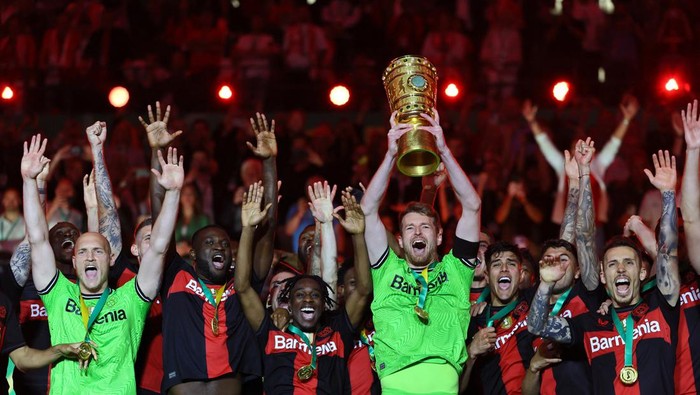 Soccer Football - DFB Cup - Final - 1.FC Kaiserslautern v Bayer Leverkusen - Olympiastadion, Berlin, Germany - May 25, 2024 Bayer Leverkusens Lukas Hradecky celebrates with the trophy after winning the DFB Cup REUTERS/Wolfgang Rattay DFB REGULATIONS PROHIBIT ANY USE OF PHOTOGRAPHS AS IMAGE SEQUENCES AND/OR QUASI-VIDEO.