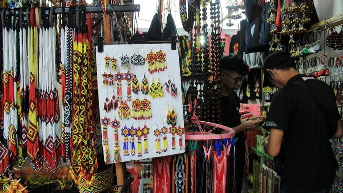 Pengunjung memilih aksesoris manik-manik khas Dayak yang dijual di arena bazar Pekan Gawai Dayak ke-38 di Rumah Radakng, Pontianak, Kalimantan Barat, Sabtu (25/5/2024). Beragam aksesoris manik-manik, hiasan kepala, hiasan baju, syal dan tas dari kain tenun yang merupakan hasil kerajinan dari perajin Suku Dayak tersebut dijual seharga Rp15 ribu hingga ratusan ribu per buah. ANTARA FOTO/Jessica Wuysang/aww.
