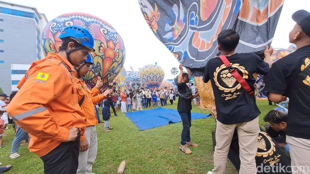 Petugas PLN turut mengawasi balon udara yang diterbangkan dengan tetap diikat tali di Lapangan Kampus Universitas Muhammadiyah Purwokerto, Minggu (26/5/2024).