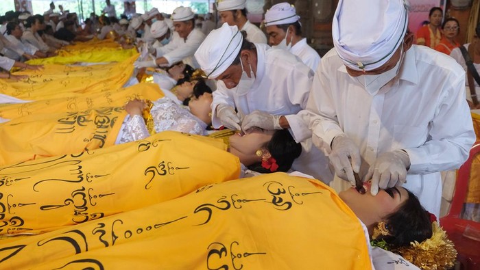 Metatah, Ritual Potong Gigi untuk Anak Beranjak Dewasa di Bali Sejumlah perempuan Bali mengikuti ritual Metatah atau potong gigi massal di Gedung Kesenian I Ketut Maria, Tabanan, Bali, Minggu (26/5/2024). Kegiatan yang digelar oleh Pemerintah Kabupaten Tabanan bersama Angel Hearts Bali Foundation tersebut diikuti 403 umat Hindu untuk membantu meringankan beban biaya masyarakat dalam melaksanakan upacara yang bermakna menghilangkan enam sifat buruk manusia saat mulai beranjak dewasa. ANTARA FOTO/Nyoman Hendra Wibowo/foc.