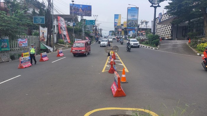 Satlantas Polres Bogor menerapkan sistem satu arah atau one way arah Jakarta di Jl Raya Puncak, Bogor, Jawa Barat, Minggu (26/5/2024). Sementara arus lalu lintas (lalin) kendaraan menuju kawasan Puncak ditutup sementara.