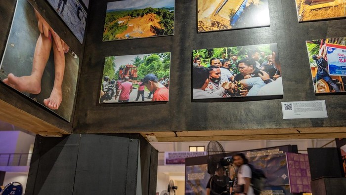 Pengunjung berjalan di belakang foto-foto pada pameran foto Hari Anti Tambang (Hatam) di Palu, Sulawesi Tengah. Minggu (26/5/2024). Dalam rangka memperingati Hari Anti Tambang yang jatuh pada 29 Mei, pameran yang diinisiasi Jaringan Advokasi Tambang (Jatam) Sulteng itu juga untuk menunjukkan kepada khalayak tentang dampak buruk dari industri ekstraktif baik terhadap kesehatan maupun terhadap lingkungan. ANTARA FOTO/Basri Marzuki/rwa.