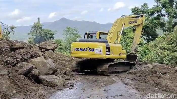 Ekskavator saat membersihkan material longsor di Jalan Poros Maros-Bone di Tompo Ladang.