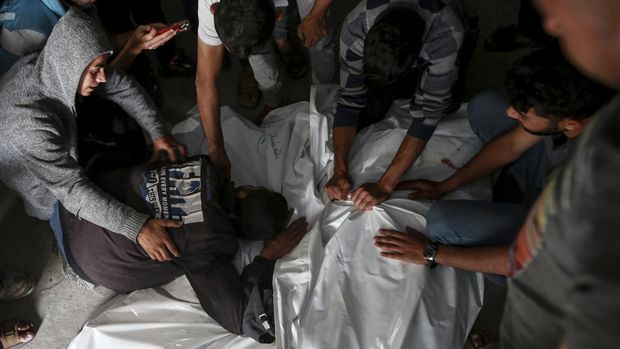 Palestinians mourn over the bodies of relatives killed in an Israeli airstrike, at a morgue in Rafah, Gaza Strip, Monday, May 27, 2024. Palestinian health workers said Israeli airstrikes Sunday killed at least 35 people sheltering in a tent camp for displaced people. Israel's army confirmed the strike and said it hit a Hamas installation and killed two senior Hamas militants. (AP Photo/Jehad Alshrafi)