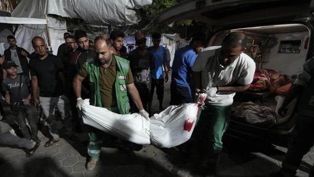 Petugas medis Palestina memindahkan jenazah korban pemboman Israel di Jalur Gaza ke kamar mayat rumah sakit Al Aqsa di Deir al Balah, Jalur Gaza tengah, pada Minggu, 26 Mei 2024. (AP Photo/Abdel Kareem Hana)