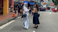 Sahila membagikan potret kedekatan dengan sang kakak saat jalan-jalan di Singapura. Terlihat mereka jajan gorengan di sana sehingga mengingatkan Sahila akan masa kecilnya yang manis. Foto: Instagram sahilahisyam
