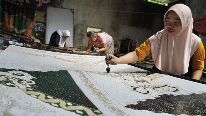 Produksi batik tulis khas Lumajang Sejumlah pekerja menyelesaikan pembuatan batik tulis di rumah produksi Batik Ismoyo, Lumajang, Jawa Timur, Senin (27/5/2024). Rumah produksi batik tersebut mengangkat potensi unggulan Kabupaten Lumajang melalui batik motif pisang yang telah dipasarkan ke Singapura dan Malaysia dengan harga Rp150 ribu hingga Rp4,8 juta per potong. ANTARA FOTO/Irfan Sumanjaya/aww.
