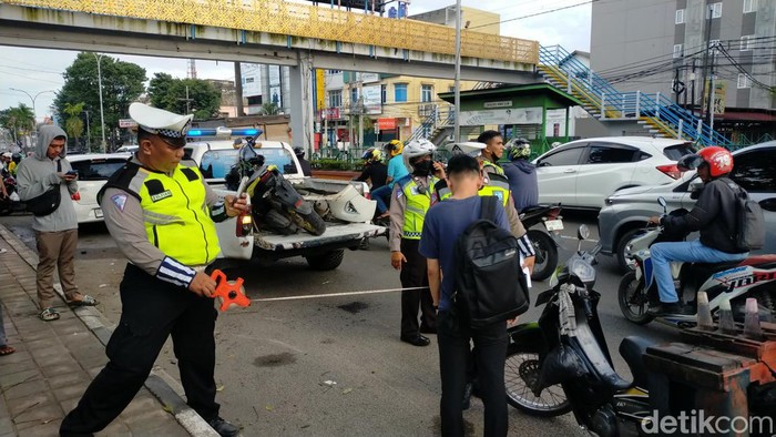 Proses evakuasi mobil dan sepeda motor yang terlibat Lakalantas
