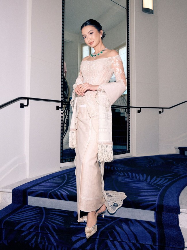 Jadilah sebuah look kebaya modifikasi yang modern tanpa meninggalkan akar budaya. Tidak seperti kebaya tradisional pada umumnya dengan pakem berupa bukaan berkancing seperti sebuah blus, Sapto menghadirkannya dengan garis leher off-shoulder yang mengekspos area bahu sehingga semakin menonjolkan kemewahan kalung statement berhiaskan deretan batu zamrud dari rumah perhiasan Chopard. (Foto: Dok. Sapto Djojokartiko)