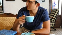 Suka nongkrong di kafe dengan nuansa yang klasik, Rio tampil santai ketika menikmati secangkir kopi yang disukainya. Foto: Instagram @rharyantoracing