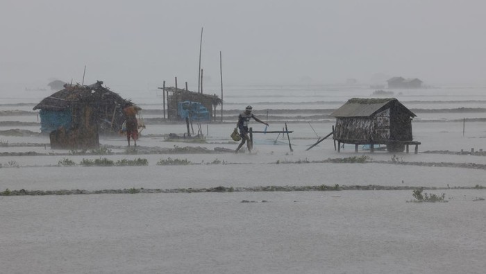 Topan Remal Menerjang Bangladesh, Pohon hingga Tiang Listrik Tumbang People walk past a fallen tree branch as Cyclone Remal hits the country, in the Shyamnagar area of Satkhira, Bangladesh, May 27, 2024. REUTERS/Mohammad Ponir Hossain