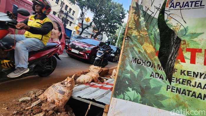 Ada Galian Kabel, Jalur Pedestrian Jalan Wijaya Jaksel Jadi Acak-acakan Warga melintasi proyek galian kabel fiber optik di Jl Wijaya I, Jakarta Selatan, Selasa (28/5/2024).
