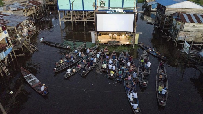 Spectators watch a film from boats during the Muyuna Floating Film Festival, showcasing films from countries with tropical forests, in the Belen neighborhood of Iquitos, Peru, on Sunday, May 26, 2024. (AP Photo/Rodrigo Abd)