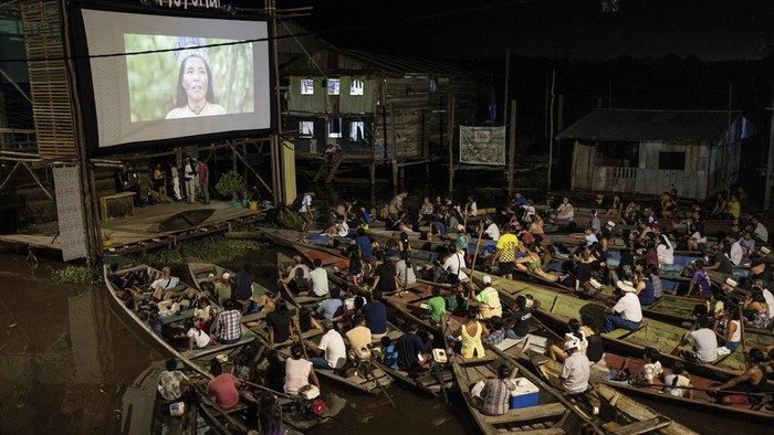 Spectators watch a film from boats during the Muyuna Floating Film Festival, showcasing films from countries with tropical forests, in the Belen neighborhood of Iquitos, Peru, on Sunday, May 26, 2024. (AP Photo/Rodrigo Abd)