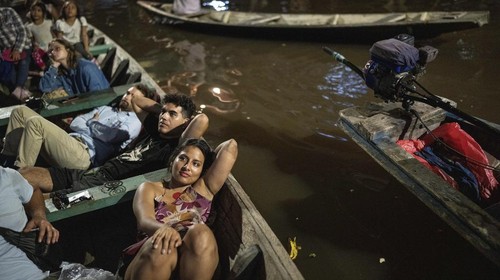 Spectators watch a film from boats during the Muyuna Floating Film Festival, showcasing films from countries with tropical forests, in the Belen neighborhood of Iquitos, Peru, on Sunday, May 26, 2024. (AP Photo/Rodrigo Abd)
