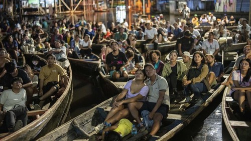 Spectators watch a film from boats during the Muyuna Floating Film Festival, showcasing films from countries with tropical forests, in the Belen neighborhood of Iquitos, Peru, on Sunday, May 26, 2024. (AP Photo/Rodrigo Abd)