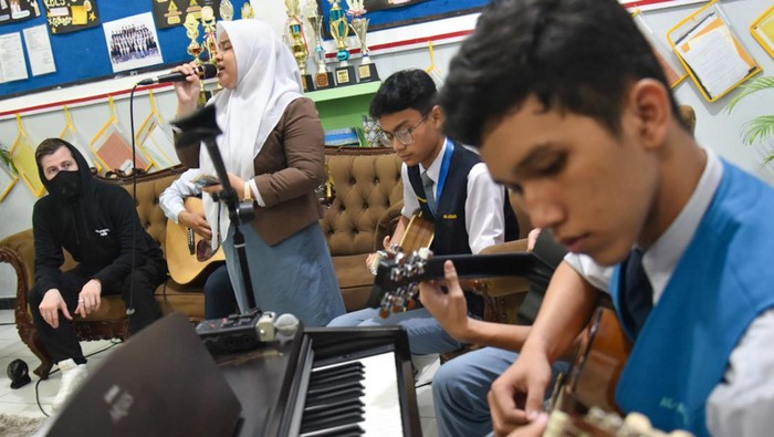 Musisi Alan Walker (kiri) menyapa para pelajar saat mengunjungi SMA Al-Azhar di Medan, Sumatera Utara, Selasa (28/5/24). Kedatangan produser musik elektrik asal Norwegia tersebut untuk mengunjungi guru musik bernama Tri Adinata yang viral karna menyanyikan lagu miliknya sekaligus mengajaknya tampil pada konser bertajuk Walkerworld di Jakarta pada 8 Juni 2024. ANTARA FOTO/Fransisco Carolio/Spt.