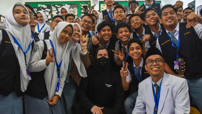 Musisi Alan Walker (kiri) menyapa para pelajar saat mengunjungi SMA Al-Azhar di Medan, Sumatera Utara, Selasa (28/5/24). Kedatangan produser musik elektrik asal Norwegia tersebut untuk mengunjungi guru musik bernama Tri Adinata yang viral karna menyanyikan lagu miliknya sekaligus mengajaknya tampil pada konser bertajuk Walkerworld di Jakarta pada 8 Juni 2024. ANTARA FOTO/Fransisco Carolio/Spt.
