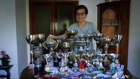 Rekor dunia terbarunya, dengan bangga memoles piala yang dipajang di ruang tamunya.