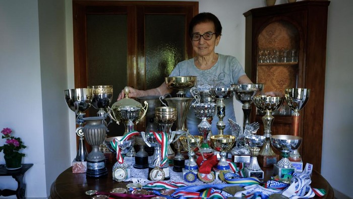 Italian master runner Emma Maria Mazzenga, 90, poses for a picture with some of her trophies, at home in Padua, Italy, May 5, 2024. REUTERS/Remo Casilli