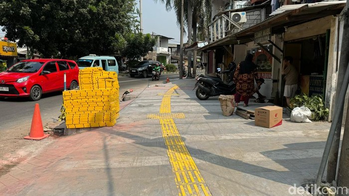 Sudin Bina Marga Jakbar menata trotoar di sejumlah titik, salah satunya di Jl Meruya Ilir Raya. Trotoar dilengkapi guiding block, bangku, hingga penerangan. (Astrid Meishella/detikcom)