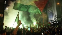 Para pengunjuk rasa mengibarkan bendara Palestina di depan gedung konsulat Israel. (AP Photo/Khalil Hamra)  