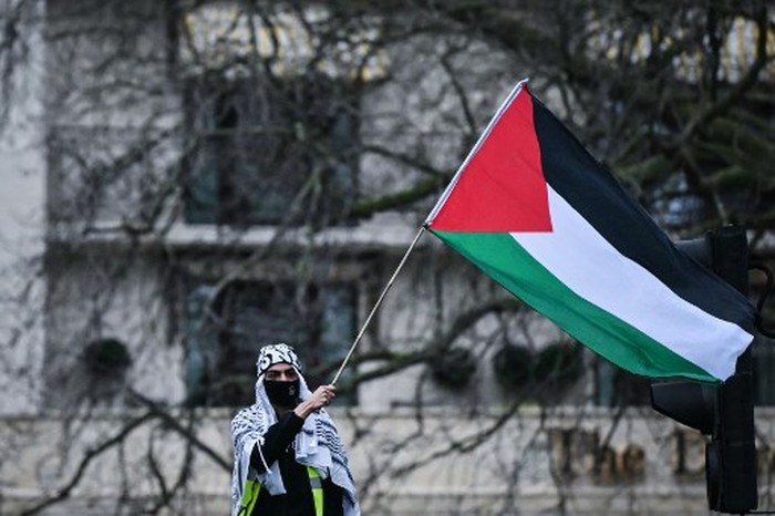 A Pro-Palestinian supporter waves a Palestinian flag during a National March for Palestine in central London on February 17, 2024. The health ministry in Hamas-run Gaza said on February 17, 2024 that at least 28,858 people have been killed in the territory during the war between Palestinian militants and Israel. The war was triggered by Hamass October 7 attack on Israel, which resulted in the deaths of around 1,160 people, according to an AFP tally based on official figures. (Photo by JUSTIN TALLIS / AFP)