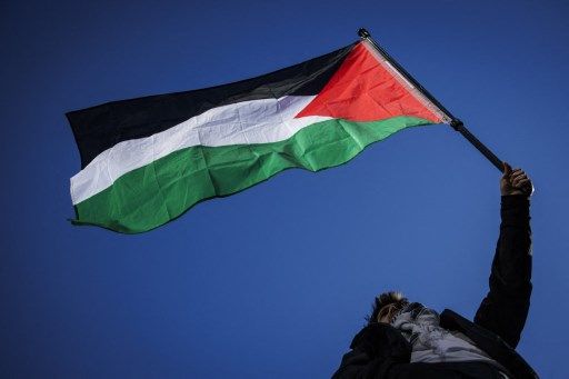 A Pro-Palestinian supporter waves a Palestinian flag during a National March for Palestine in central London on February 17, 2024. The health ministry in Hamas-run Gaza said on February 17, 2024 that at least 28,858 people have been killed in the territory during the war between Palestinian militants and Israel. The war was triggered by Hamas's October 7 attack on Israel, which resulted in the deaths of around 1,160 people, according to an AFP tally based on official figures. (Photo by JUSTIN TALLIS / AFP)