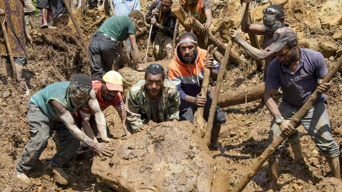 In this photo released by UNDP Papua New Guinea, villagers search through a landslide in Yambali village, in the Highlands of Papua New Guinea, Monday, May 27, 2024. Authorities fear a second landslide and a disease outbreak are looming at the scene of Papua New Guineas recent mass-casualty disaster because of water streams trapped beneath tons of debris and decaying corpses seeping downhill following the May 24 landslide. (Juho Valta/UNDP Papua New Guinea via AP)