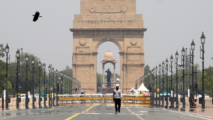 A man walks past the India Gate monument on a hot summer day in New Delhi, India, Monday, May 27, 2024. (AP Photo/Manish Swarup)