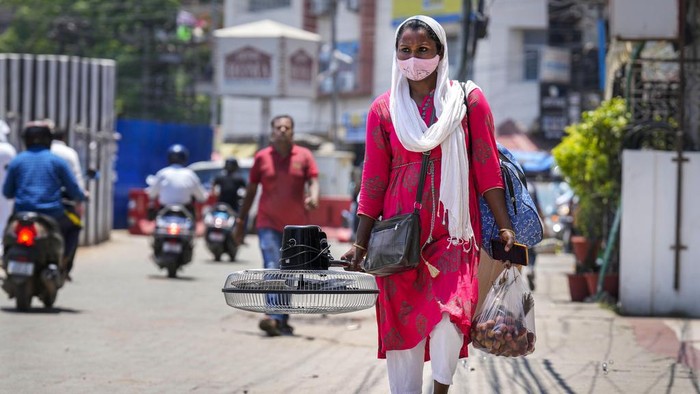 Panas Terik Berminggu-minggu 'Memanggang' India Utara A woman carries a fan purchased from a market on a hot summer day in Guwahati, India, Saturday, May 25, 2024. (AP Photo/Anupam Nath)
